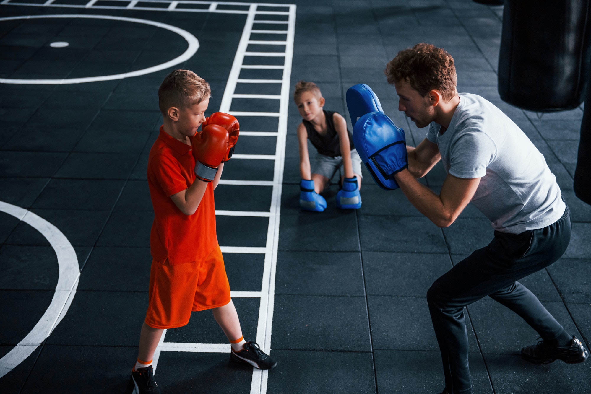 young-trainer-teaches-kids-boxing-sport-in-the-gym.jpg